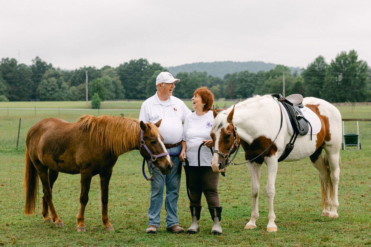 Couple standing with two horses
